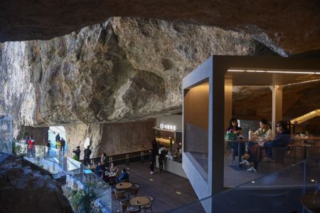 (miniature) Des touristes dans un café creusé dans une falaise du site touristique de la montagne Yandang à Yueqing