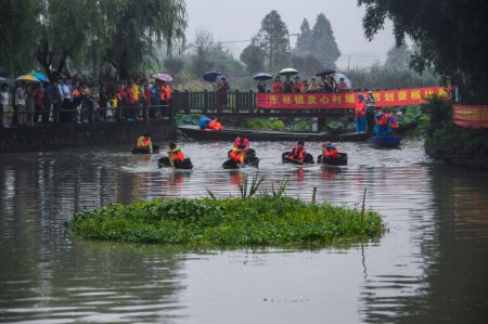 (miniature) Des villageois participent &agrave; une comp&eacute;tition d'aviron de seau au village de Quanxin de la ville de Huzhou