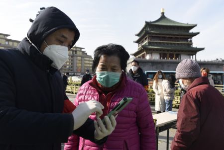 (miniature) Un membre du personnel aide une habitante à s'inscrire pour un test d'acide nucléique dans un site de dépistage à Xi'an