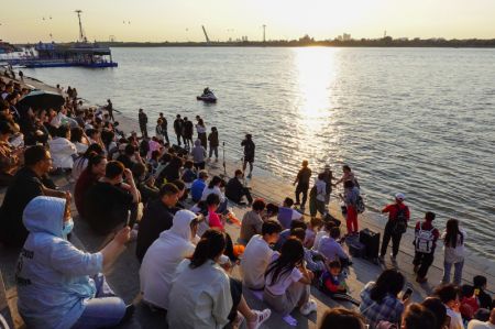 (miniature) Des gens s'amusent près du Monument pour la lutte contre les inondations situé le long de la rivière Songhua