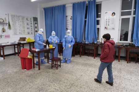 (miniature) Une habitante arrive pour le test d'acide nucl&eacute;ique sur un site de d&eacute;pistage dans un coll&egrave;ge de Harbin