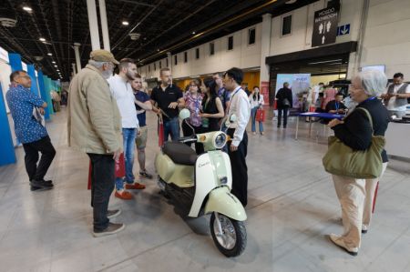 (miniature) Des gens regardent une moto électrique exposée à la China Brand Fair 2024 à Budapest