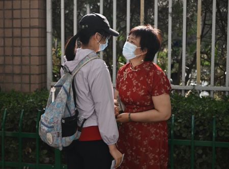 (miniature) Une femme encourage sa fille devant un site d'examen du lycée expérimental rattaché à l'Université normale de Beijing