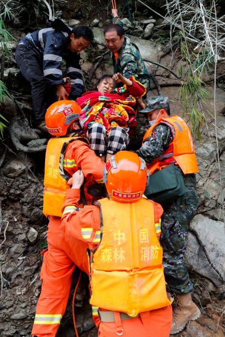 (miniature) Des secouristes transfèrent une villageoise blessée rescapée du village de Wandong