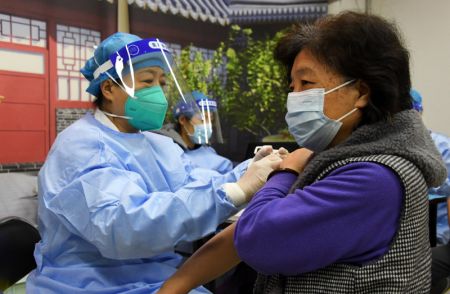 (miniature) Une employée médicale injecte un rappel du vaccin contre la COVID-19 à une résidente sur un site de vaccination temporaire à Beijing