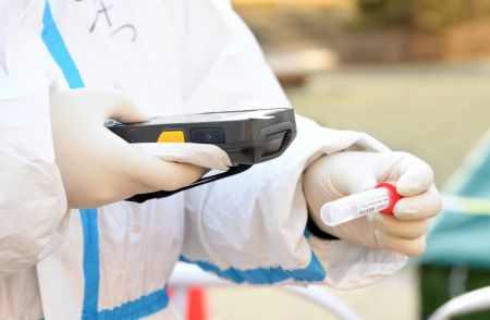 (miniature) Un membre du personnel m&eacute;dical enregistre les informations d'un tube de test d'acide nucl&eacute;ique dans un site de d&eacute;pistage de l'arrondissement de Shunyi &agrave; Beijing