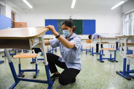 (miniature) Une employée arrange des bureaux à l'école secondaire No