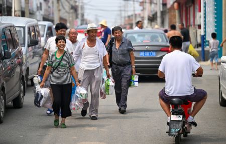 (miniature) Des villageois se saluent à leur retour chez eux dans le bourg de Taitou de l'arrondissement de Jinghai