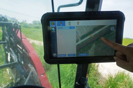 (miniature) Un technicien agricole met au point l'itin&eacute;raire de travail d'une moissonneuse autonome dans un bourg du district de Nanchang