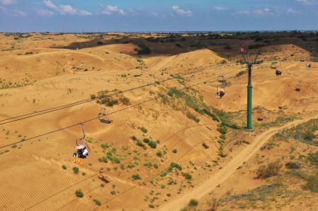 (miniature) Photo aérienne prise par un drone montrant des touristes en télésièges dans le site touristique du désert de Yinkentala de la bannière de Dalad