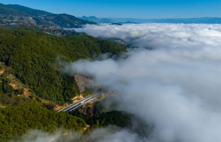 (miniature) Photo aérienne prise le 10 décembre 2022 d'une autoroute enveloppée par une mer de nuages à Lincang