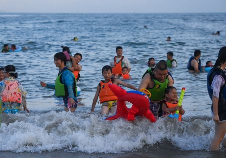 (miniature) Des touristes s'amusent au bord de la mer