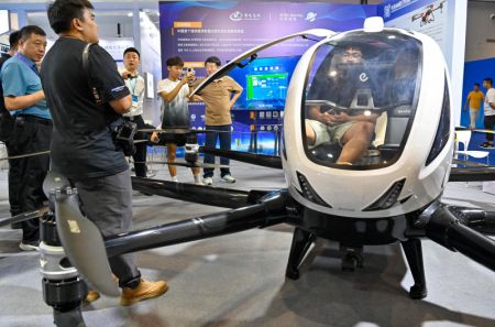 (miniature) Des visiteurs observent un drone lors du Salon international de l'optoélectronique de Changchun 2024 à Changchun