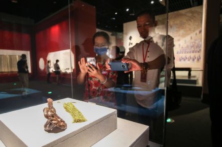 (miniature) Des gens visitent une exposition d'objets du Musée du palais