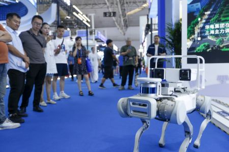 (miniature) Des visiteurs observent un chien robot d'inspection sur le stand du China Huadian Group lors de la 8e Exposition Chine-Eurasie