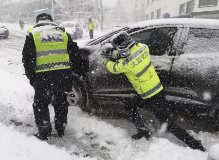 (miniature) Un policier aide &agrave; pousser une voiture sous une forte chute de neige &agrave; Dalian