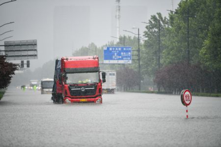 (miniature) Un véhicule roule dans une rue inondée de Zhengzhou