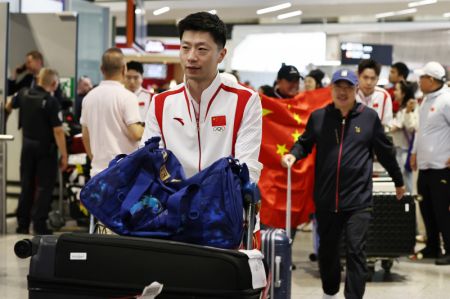 (miniature) Ma Long (devant) de l'équipe chinoise de tennis de table arrive à l'aéroport Roissy-Charles de Gaulle pour les prochains Jeux olympiques de Paris 2024