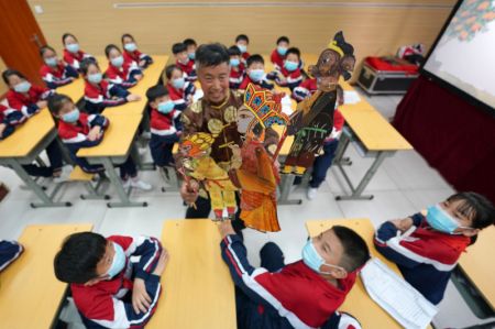 (miniature) Un artiste présente des poupées d'ombres à des élèves du Collège no 6 de Shahe