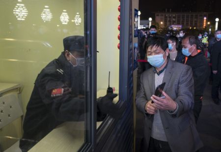 (miniature) Un passager montre son code de santé à un membre du personnel ferroviaire dans la gare de Wuchang
