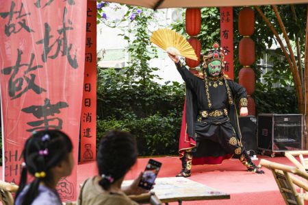 (miniature) Des touristes regardent un spectacle de visage changeant de l'Opéra du Sichuan dans une maison de thé en plein air dans la ruelle Shancheng à Yuzhong