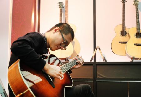 (miniature) Un homme joue de la guitare lors du salon Music China 2020