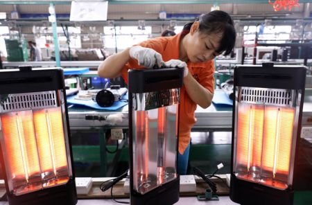 (miniature) Une ouvrière contrôle des radiateurs électriques dans une entreprise de Foshan