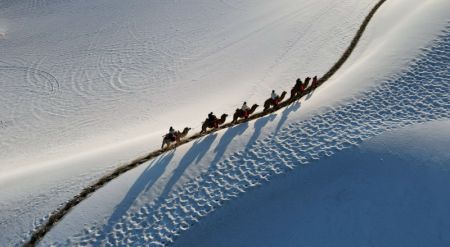 (miniature) Photo aérienne des touristes profitant du paysage enneigé du site pittoresque du mont Mingsha et de la source Yueya