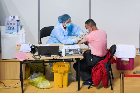 (miniature) Un homme reçoit une dose de vaccin contre le COVID-19 dans un site de vaccination de l'arrondissement de Gulou