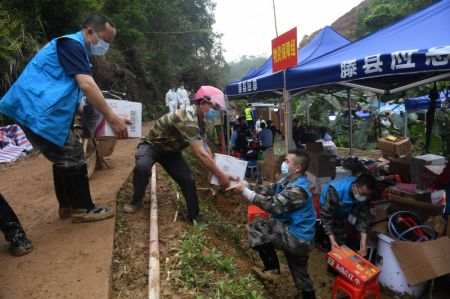 (miniature) Un motocycliste volontaire (2e à gauche) décharge des fournitures de secours sur le site du récent crash aérien