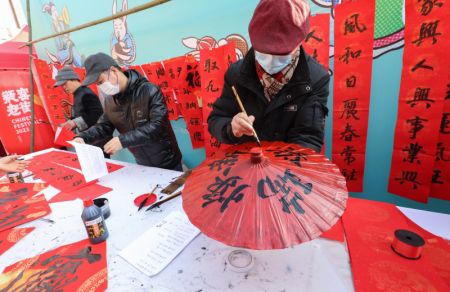 (miniature) Des gens écrivent des mots de bon augure en calligraphie chinoise comme bénédictions du Nouvel An lors d'un festival d'achats dans le bourg de Pingyao de l'arrondissement de Yuhang