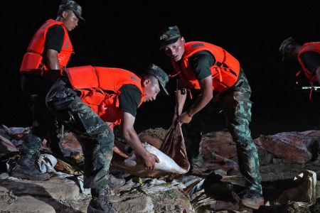 (miniature) Des policiers arm&eacute;s transportent des sacs de sable sur une digue &agrave; Poyang