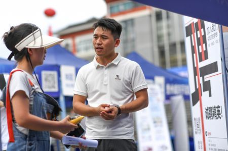 (miniature) Une diplômée d'université (à gauche) s'informe sur les opportunités d'emploi lors d'un salon de l'emploi dans la préfecture autonome Miao et Dong de Qiandongnan