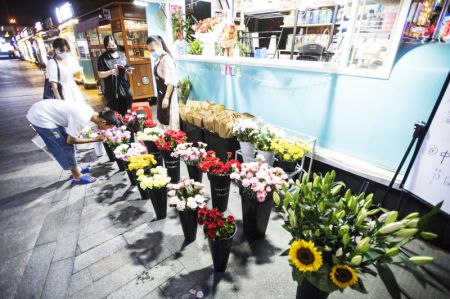 (miniature) Des gens achètent des fleurs lors de la Fête de la mi-automne