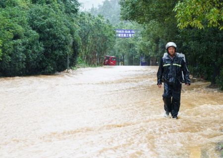 (miniature) Une personne marche sur une route inondée du district de Shexian