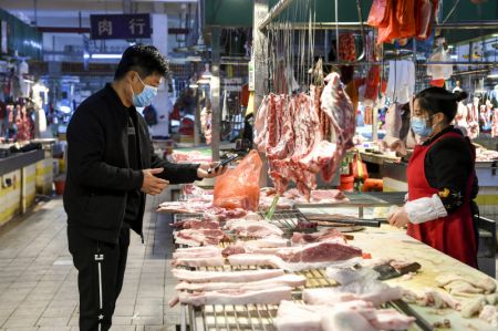 (miniature) Un habitant achète de la viande sur un marché à Dongxing