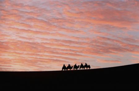 (miniature) Des gens à dos de chameau visitent les sites touristiques du mont Mingsha et de la Source du croissant de lune