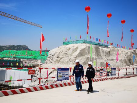 (miniature) Un ouvrier chinois et un ouvrier russe parlent en marchant dans un site de construction où les réacteurs 7 et 8 de la centrale nucléaire de Tianwan sont sur le point d'être construits