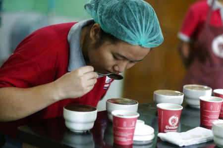 (miniature) Une ouvrière déguste du café dans une usine à Yangon