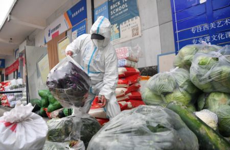 (miniature) Un bénévole assure la manutention de légumes emballés dans l'arrondissement de Yanta de Xi'an