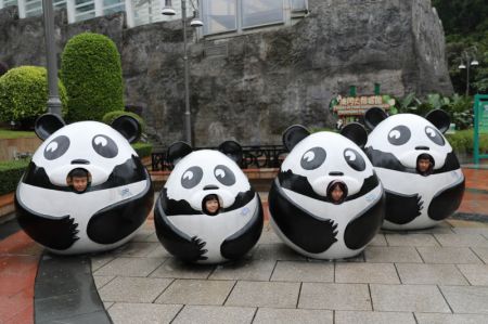 (miniature) Des enfants posant pour une photo à l'intérieur de décorations en forme de panda géant à Macao