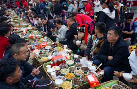 (miniature) Des touristes et des habitants locaux participent au long banquet de rue lors d'un festival de tourisme culturel dans le district de Luchun de la préfecture autonome Hani et Yi de Honghe