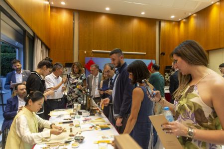 (miniature) Des gens regardent une démonstration de calligraphie chinoise à l'ambassade de Chine à Athènes