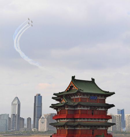 (miniature) Les avions d'une équipe sud-africaine de voltige aérienne laissent des traînées de fumée lors de leur spectacle au-dessus du pavillon Tengwang