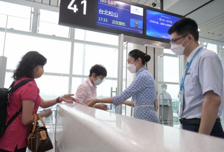 (miniature) Des passagers procèdent à une vérification de leurs cartes d'embarquement avant de monter à bord du vol MF883 à l'Aéroport international Changle de Fuzhou