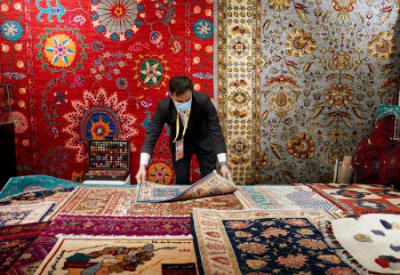 (miniature) Un marchand de tapis afghan dispose des tapis de laine fabriqués à la main lors de la 4e édition de l'Exposition internationale d'importation de la Chine (CIIE) à Shanghai