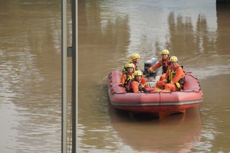 (miniature) Des secouristes patrouillent dans une zone inondée de la rue Nanbin