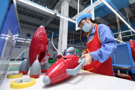 (miniature) Une employée fabrique des jouets dans une usine de produits en plastique à Zhangjiajie