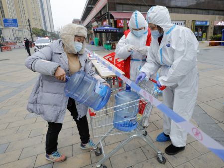 (miniature) Des employés et des bénévoles se préparent à livrer l'eau potable commandée par les habitants d'un quartier résidentiel placé en quarantaine dans l'arrondissement de Chenghua à Chengdu