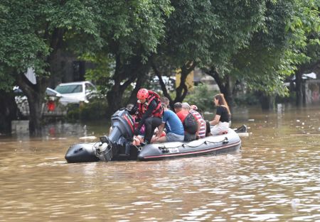 (miniature) Des secouristes aident des habitants locaux à évacuer une route inondée à Guilin